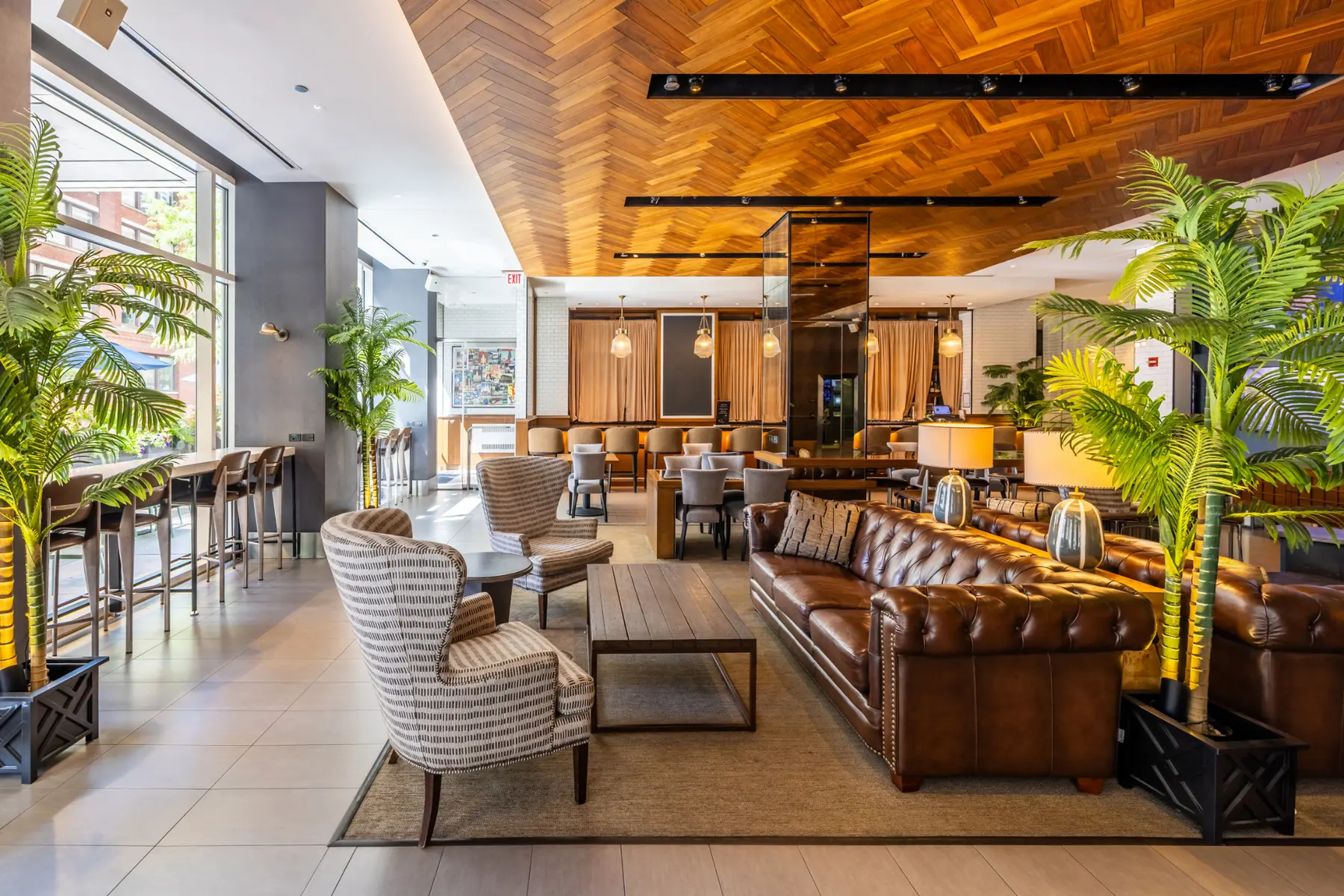 The Lobby Bar at Magnificent Mile, with leather lounge seating, dining tables and street-facing windows